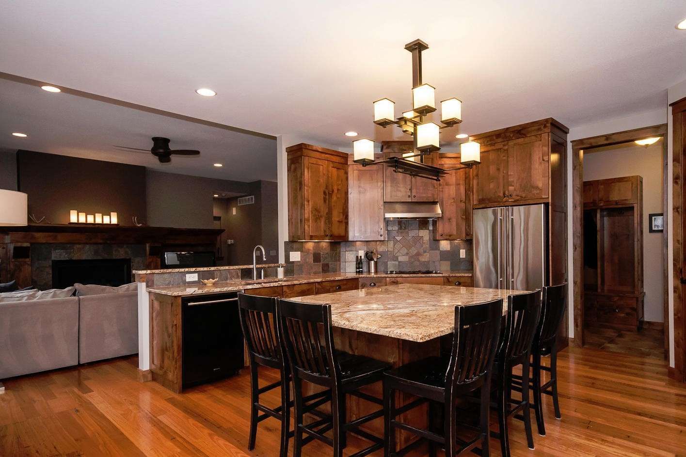 Kitchen with dark wood cabinets, granite countertops, and a large island with seating.