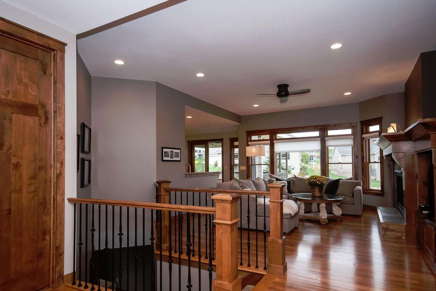 Interior view of a living room with wooden floors, neutral walls, and a staircase.