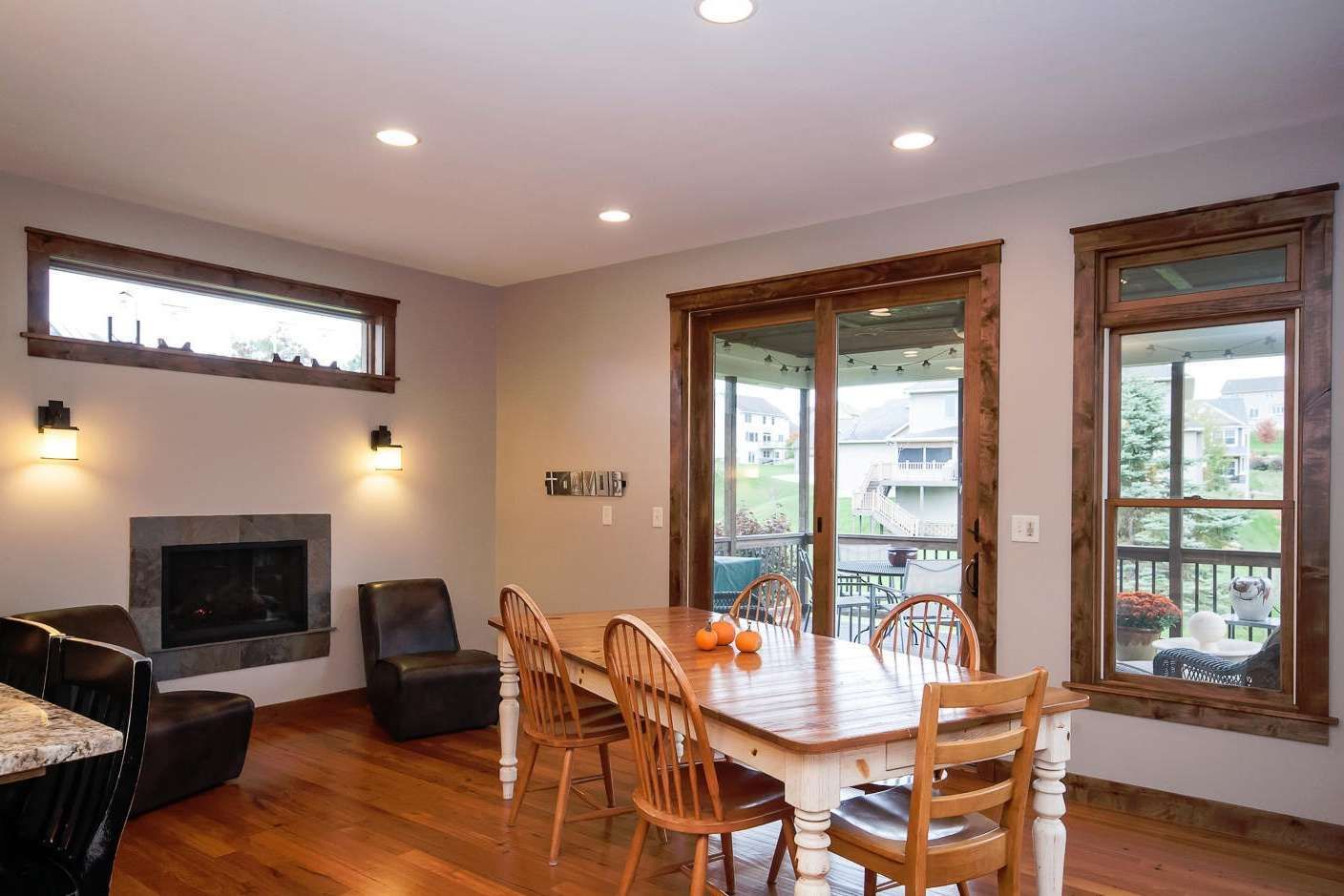 Dining room with wooden table and chairs, fireplace, and sliding glass door.
