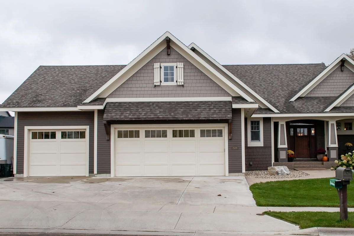 House with gray siding, two-car garage, and a gable roof with a dormer.