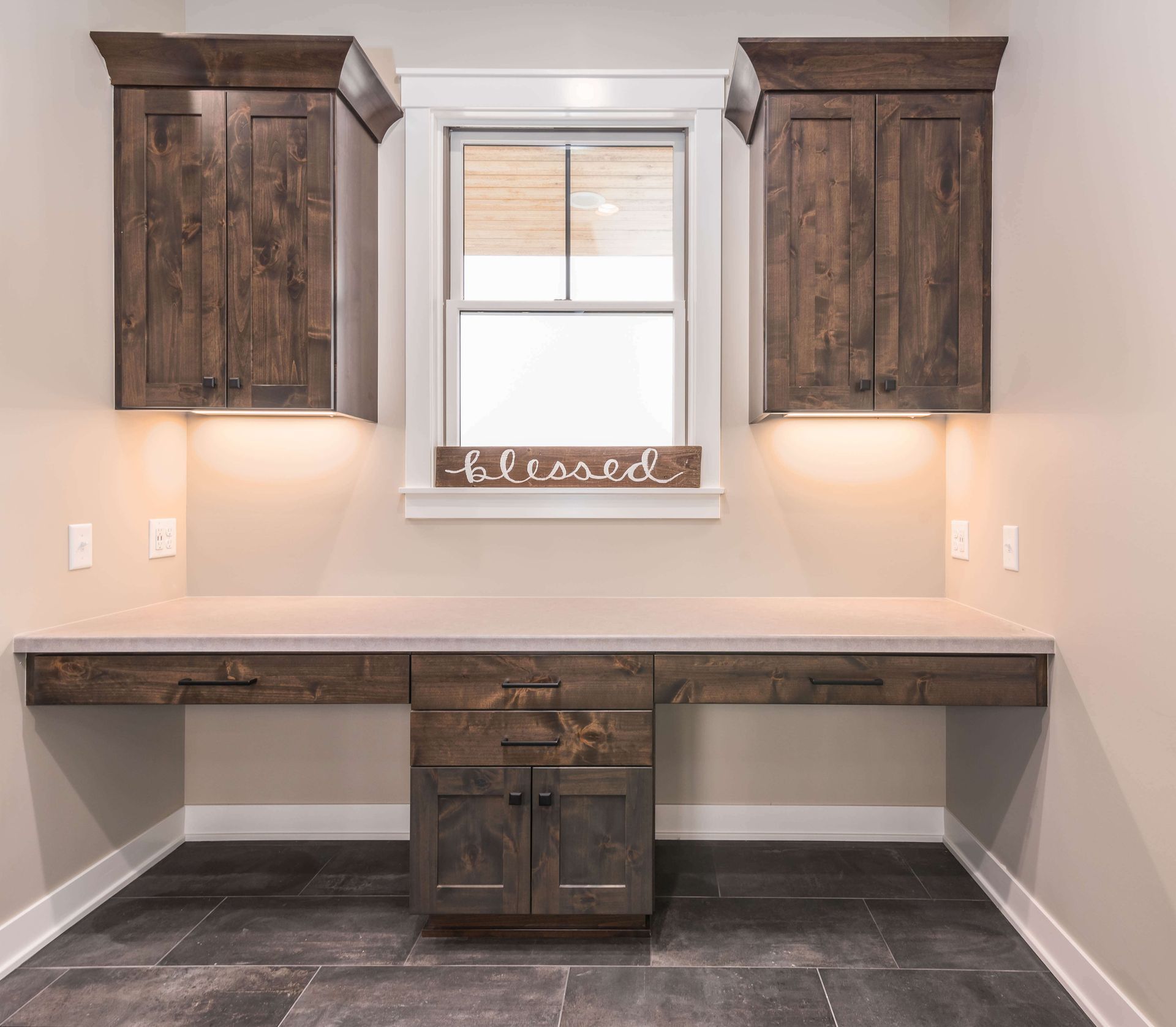 Dark wood desk and cabinets in a room with a window and 
