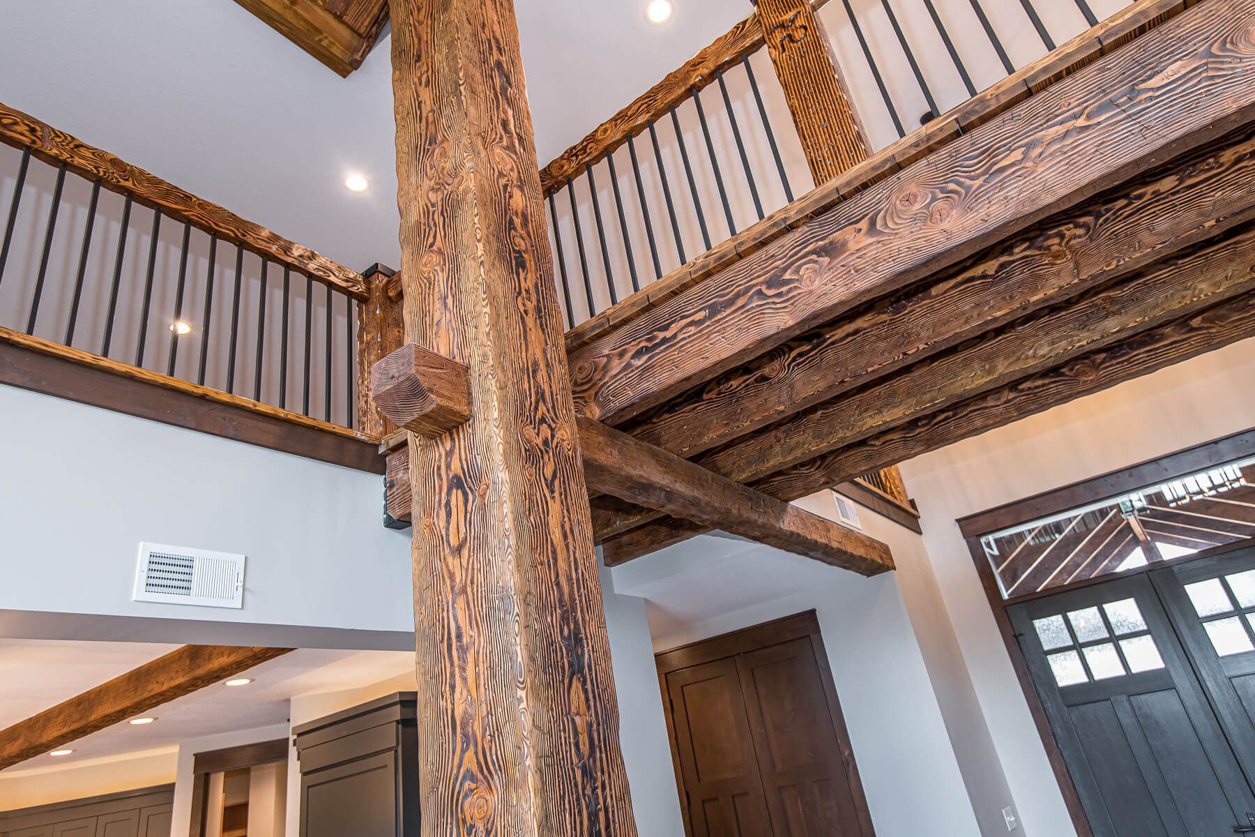 Interior view of a building with wooden beams and a second-story balcony.