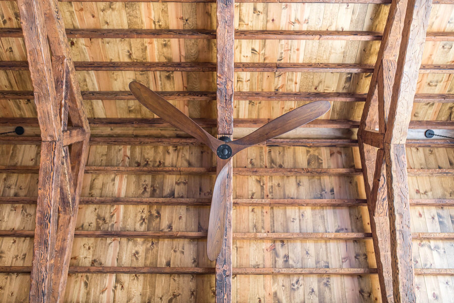 Wooden ceiling with a three-blade fan.
