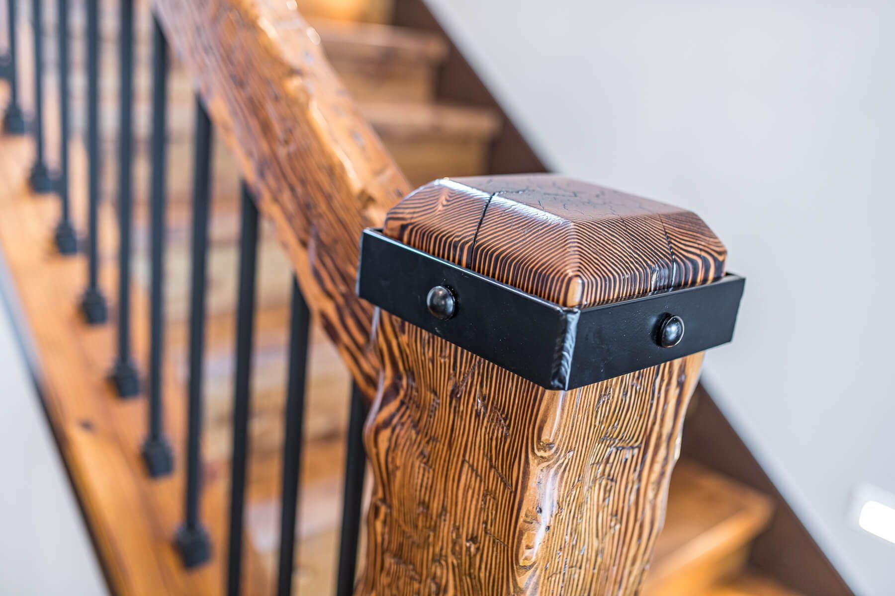 Wooden staircase with black metal accents and railing.