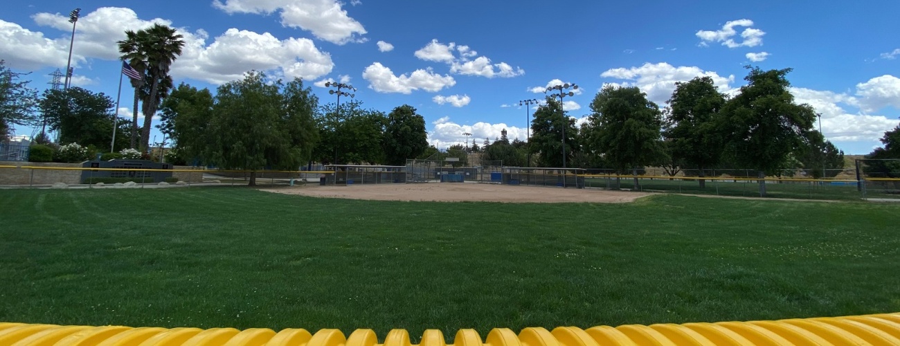 Baseball player sliding into base as another player attempts to catch the ball.