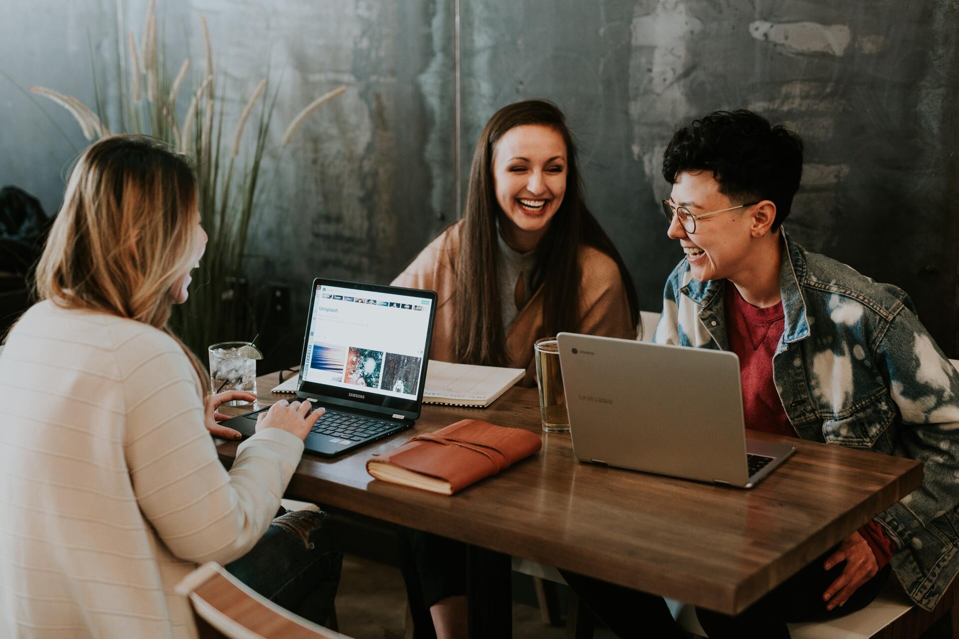 Three business women are sitting at a table discussing mobile app development