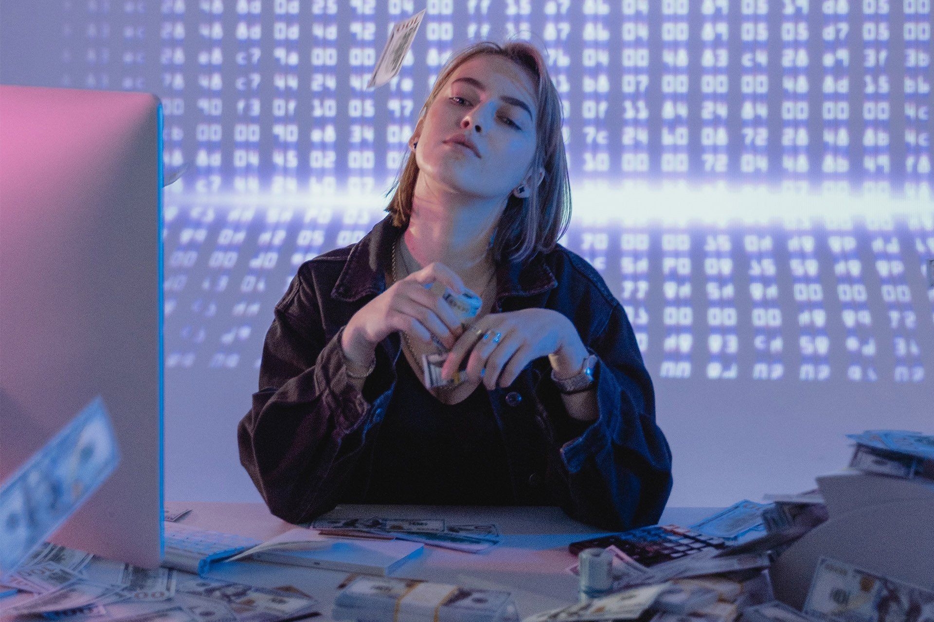 A woman is sitting at a table with a lot of money.
