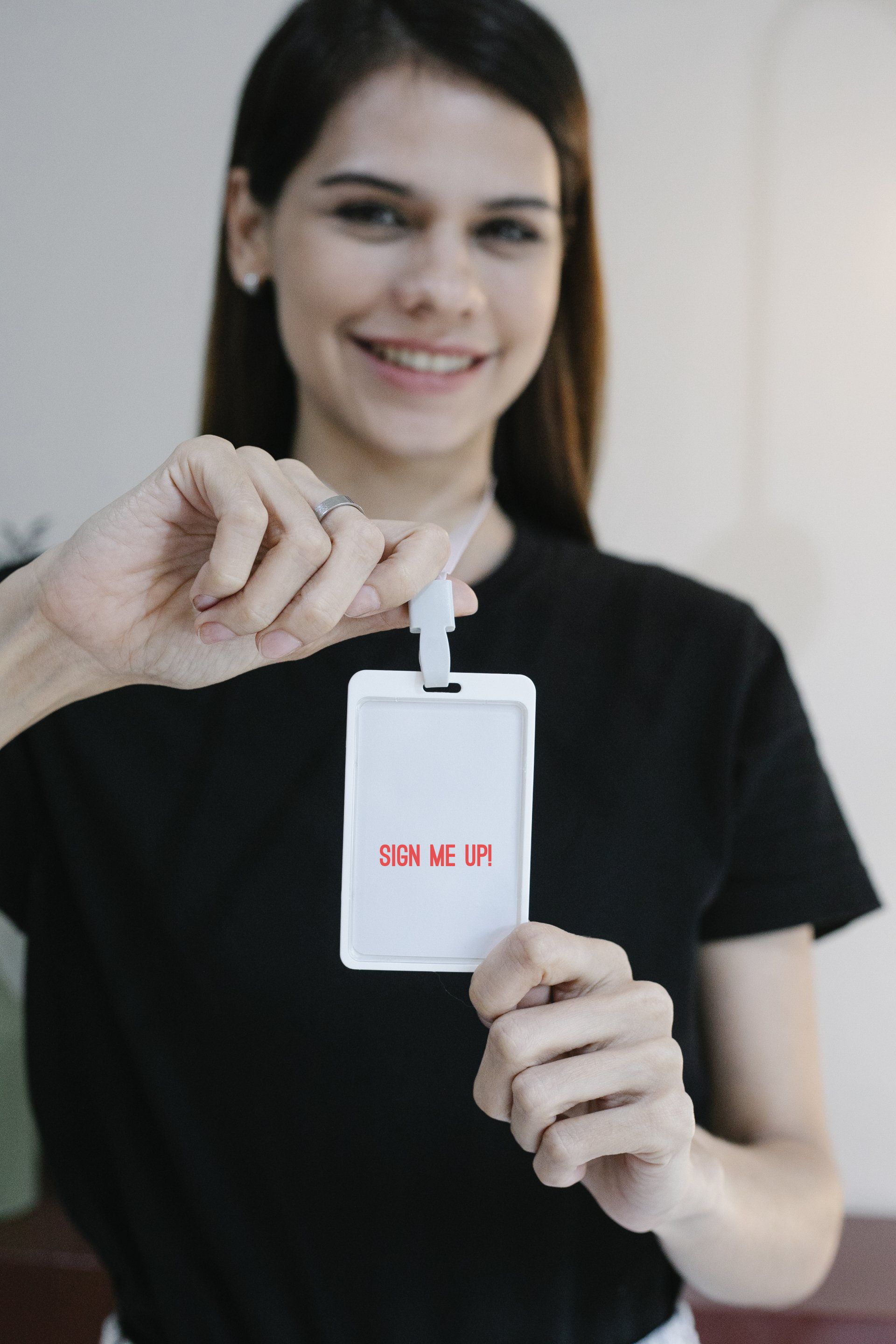 A woman showing her a membership lanyard