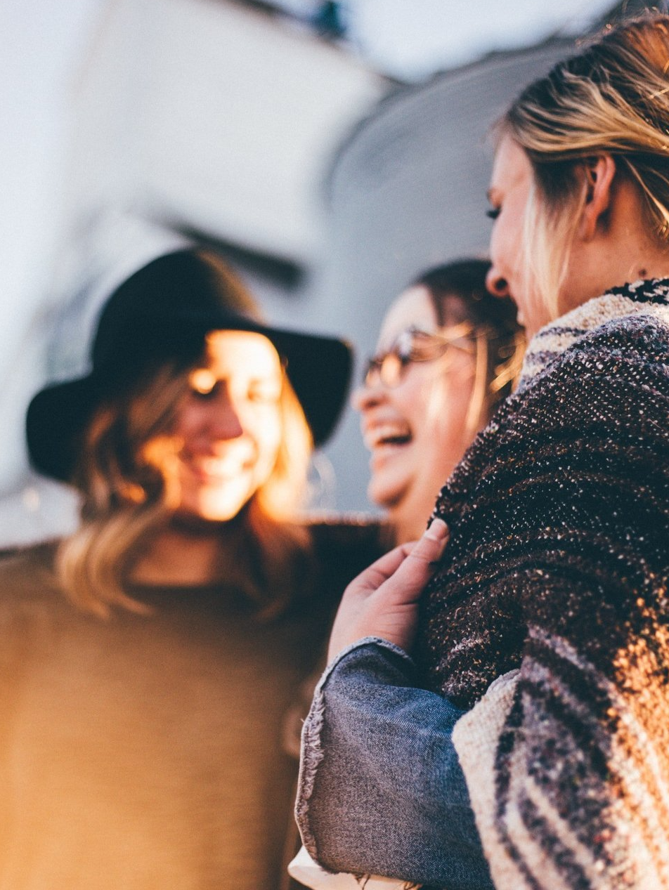A group of women are standing next to each other and laughing.