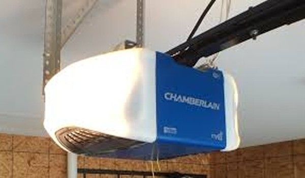 A chamberlain garage door opener is hanging from the ceiling of a garage.