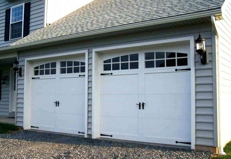 A house with three white garage doors with black handles