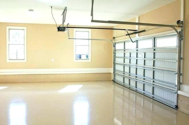An empty garage with a garage door open and a window.