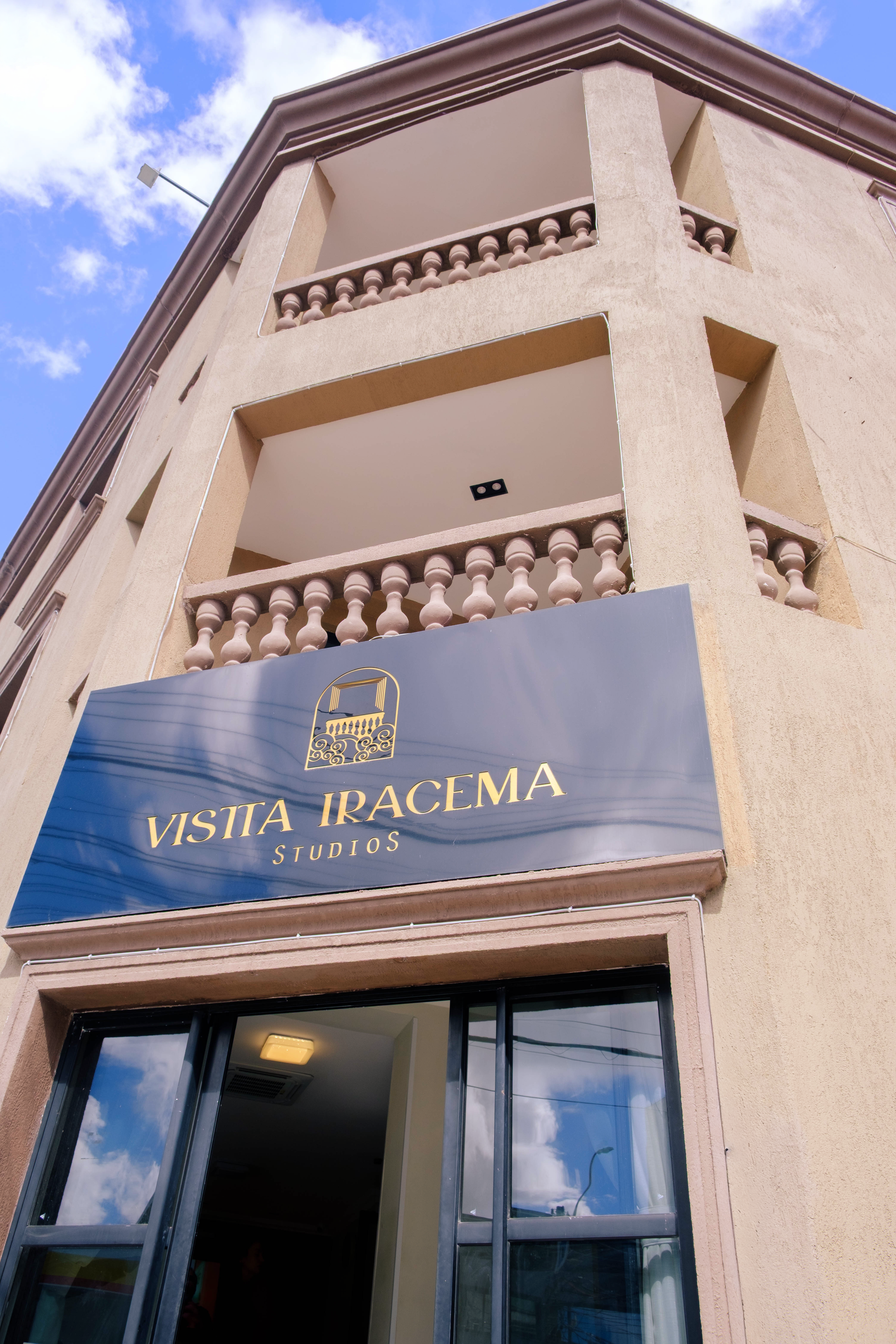 Fachada bege do edifício com varandas e uma placa com a inscrição “Asta Pacima” acima da entrada.