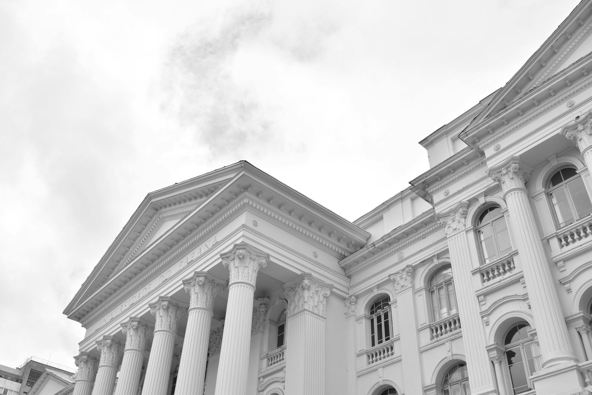 A black and white photo of a large white building with columns.