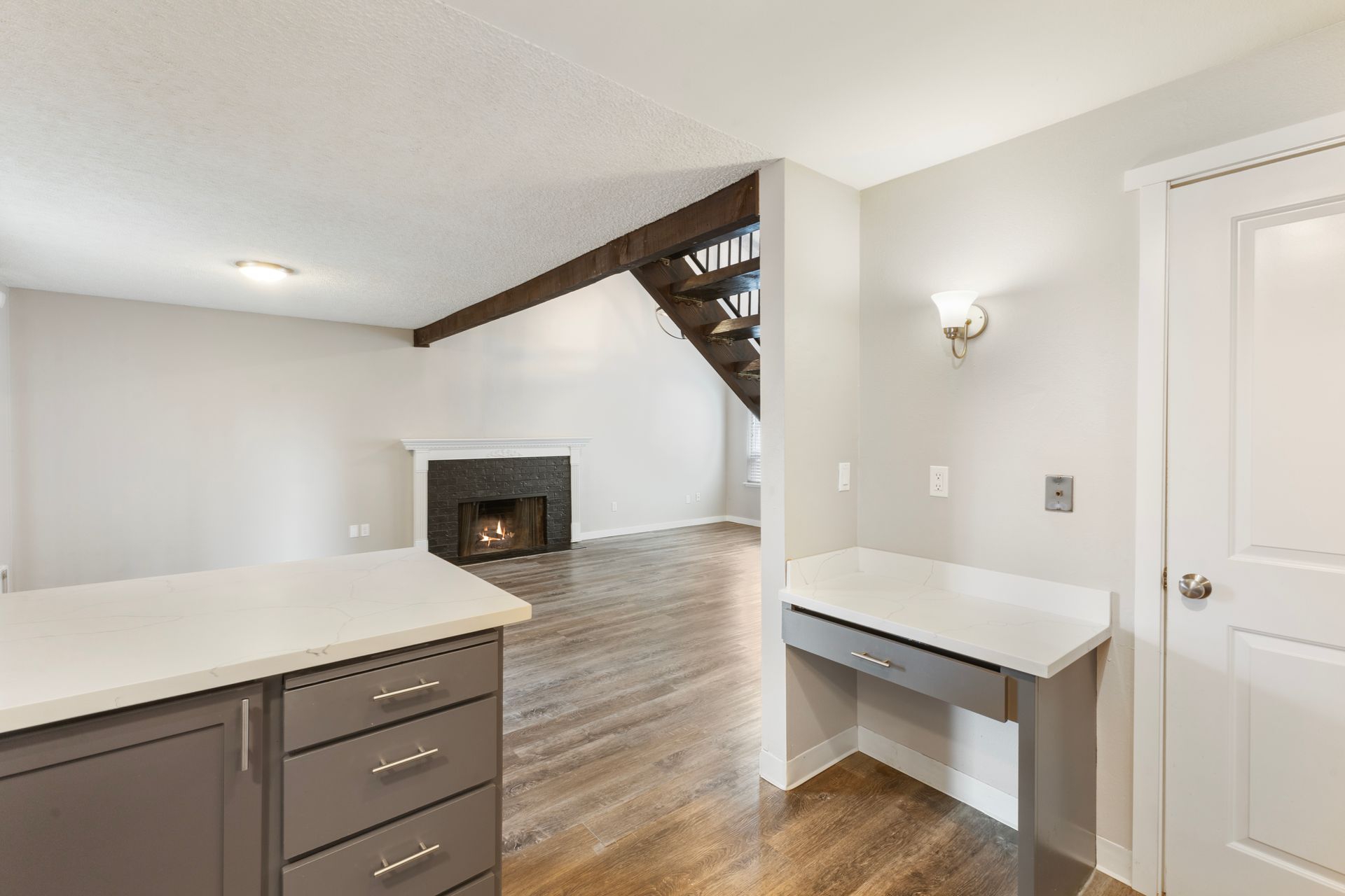 A kitchen with a desk and a fireplace in a house.