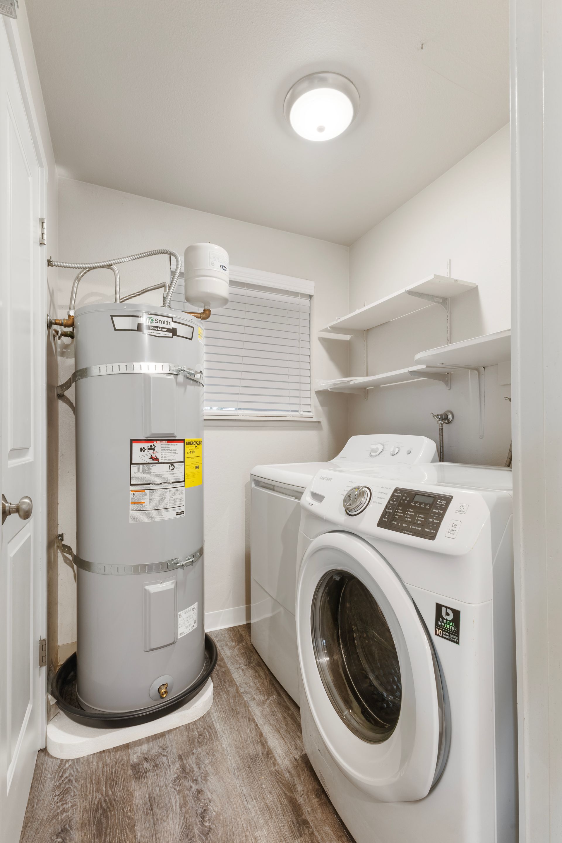 A laundry room with a washer and dryer and a water heater.
