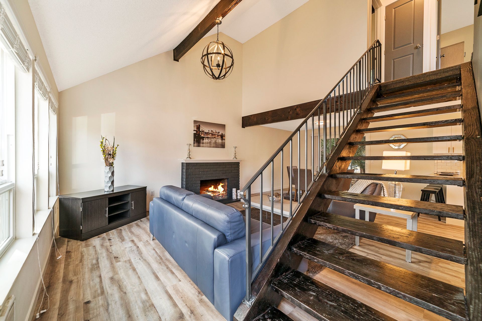 A living room with a staircase leading up to the second floor.