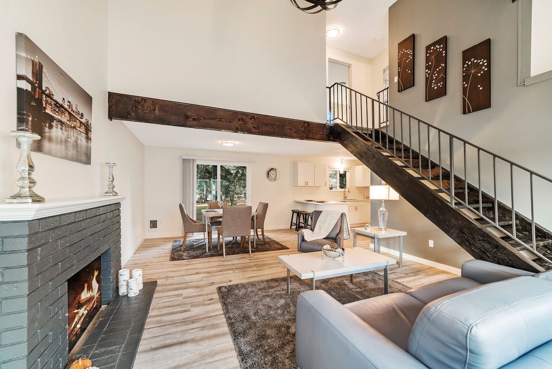 A living room with a fireplace and stairs leading up to the second floor