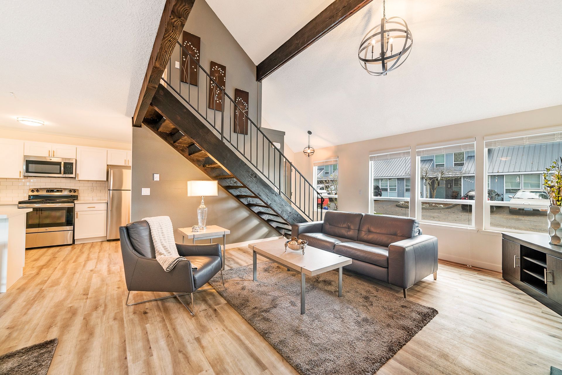 A living room with a staircase leading up to the second floor.