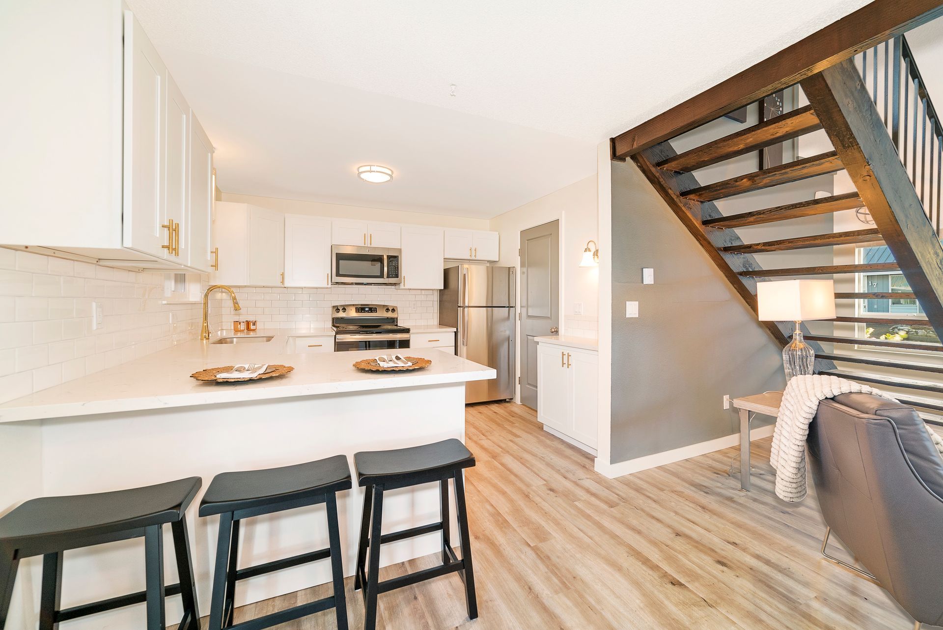 A kitchen with a staircase leading up to the second floor.