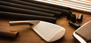 Golf clubs and club fitting components on a workbench