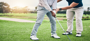 Golf instructor guiding a student's stance on the course