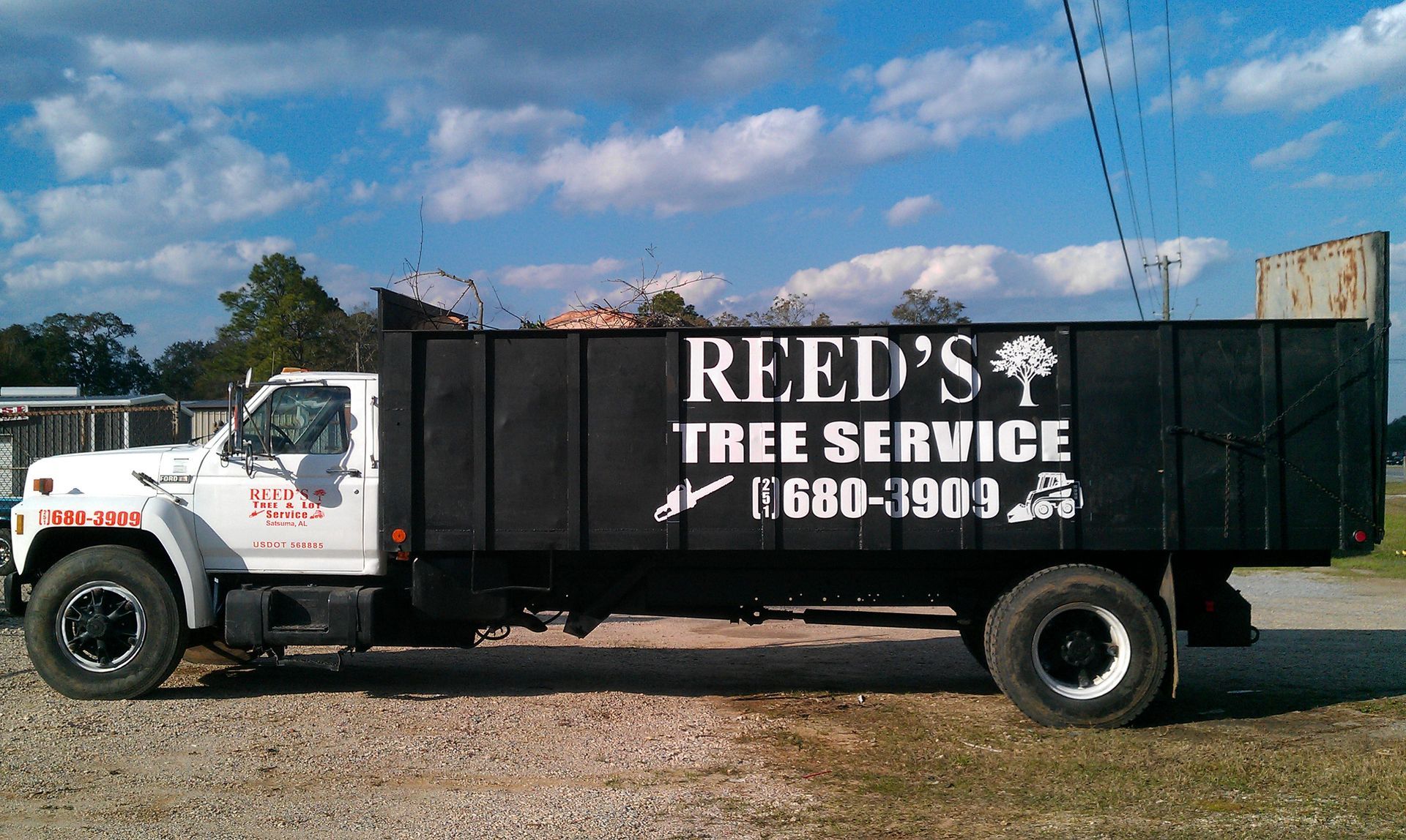 A white dump truck parked on a gravel lot with 