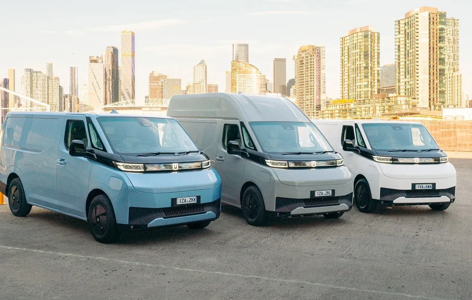 A pale green electric cargo van shown from the side against a neutral gray background.