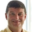 Smiling man in a light shirt against a plain white background