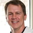 Smiling man in a white shirt against a light background