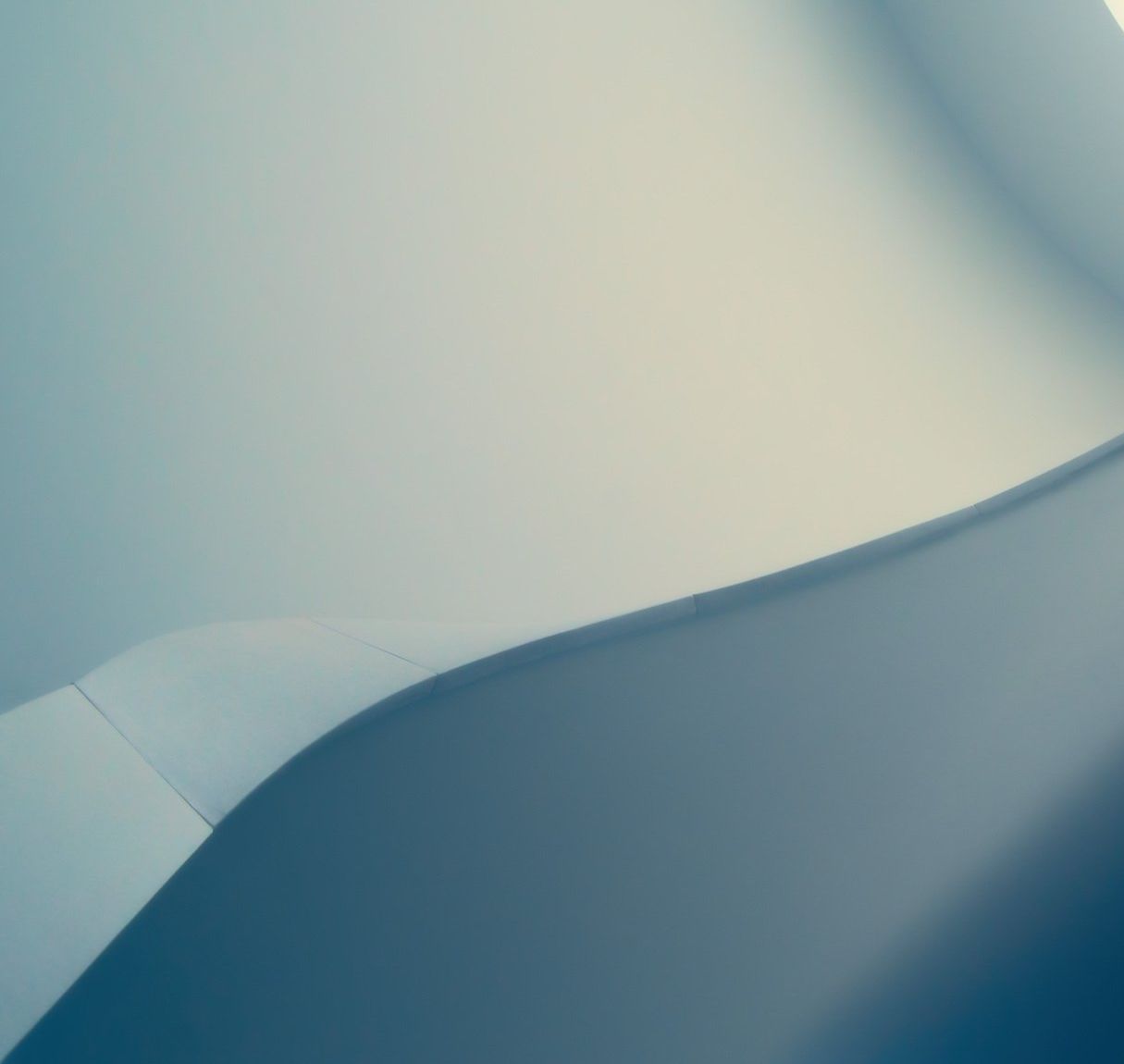 Abstract blue and beige curved gradient shapes resembling folded paper or fabric