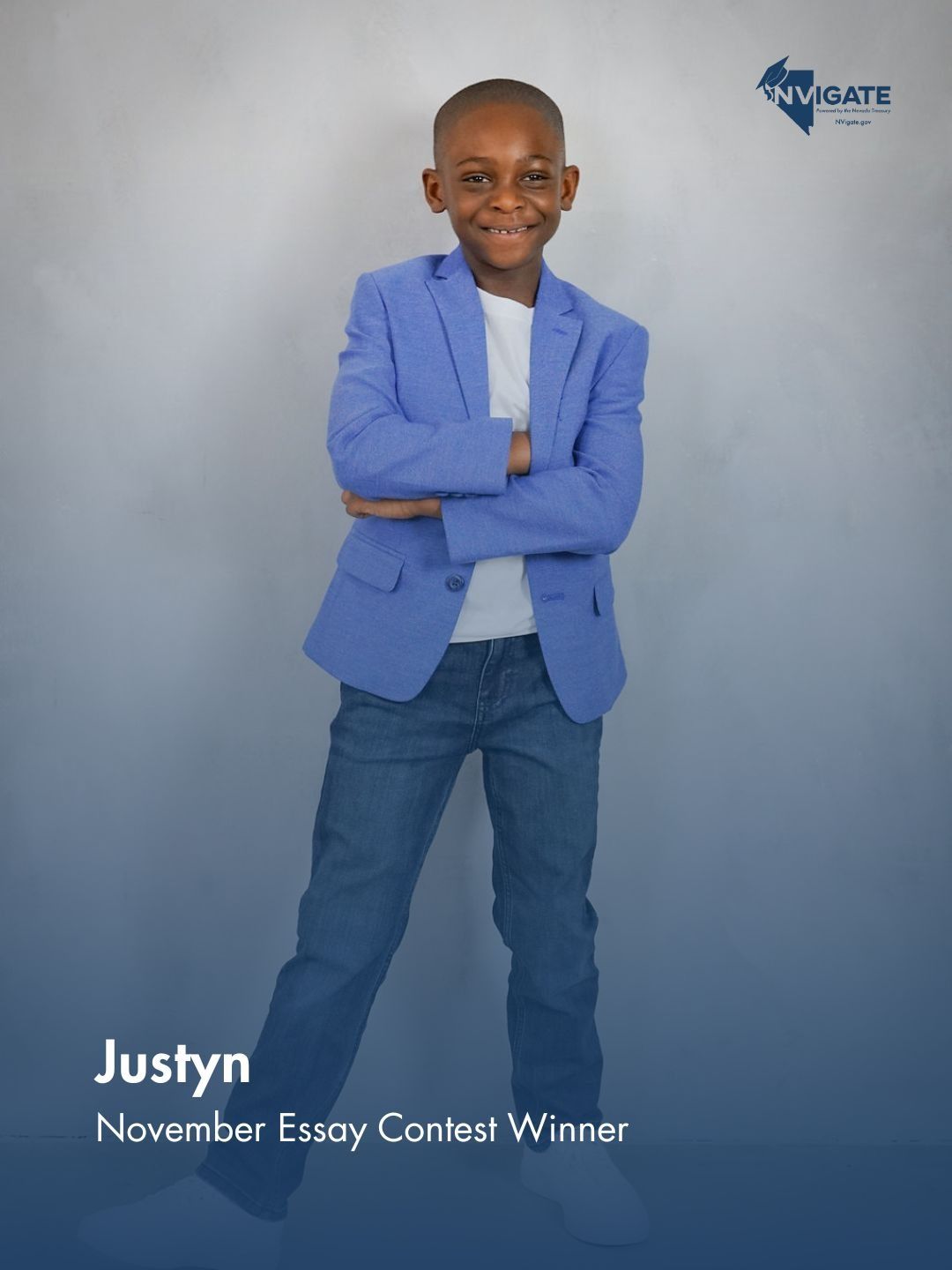 Young boy in a blue blazer and jeans posing with arms crossed; text reads “Justyn, November Essay Contest Winner.”