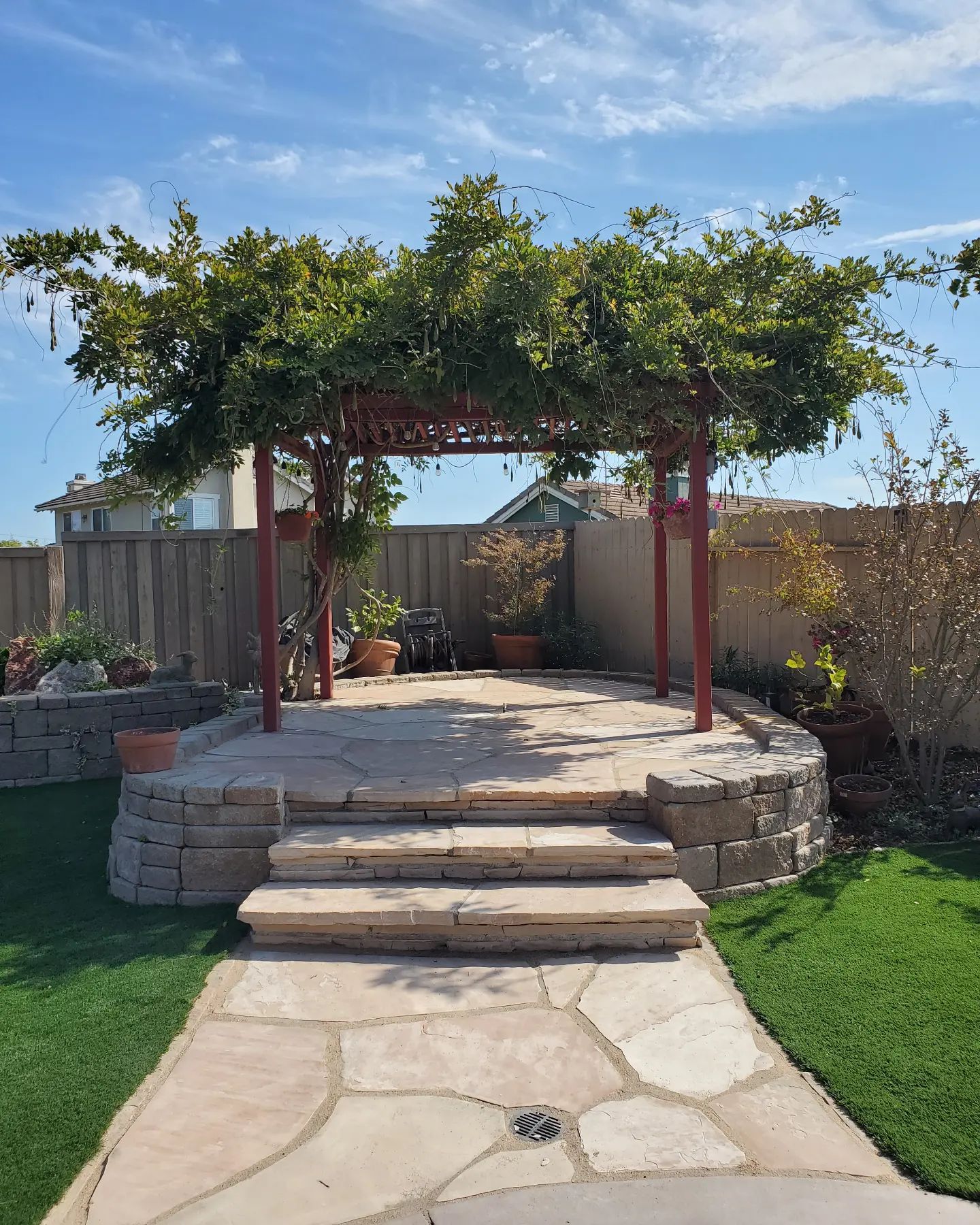 A pergola with a table and chairs underneath it