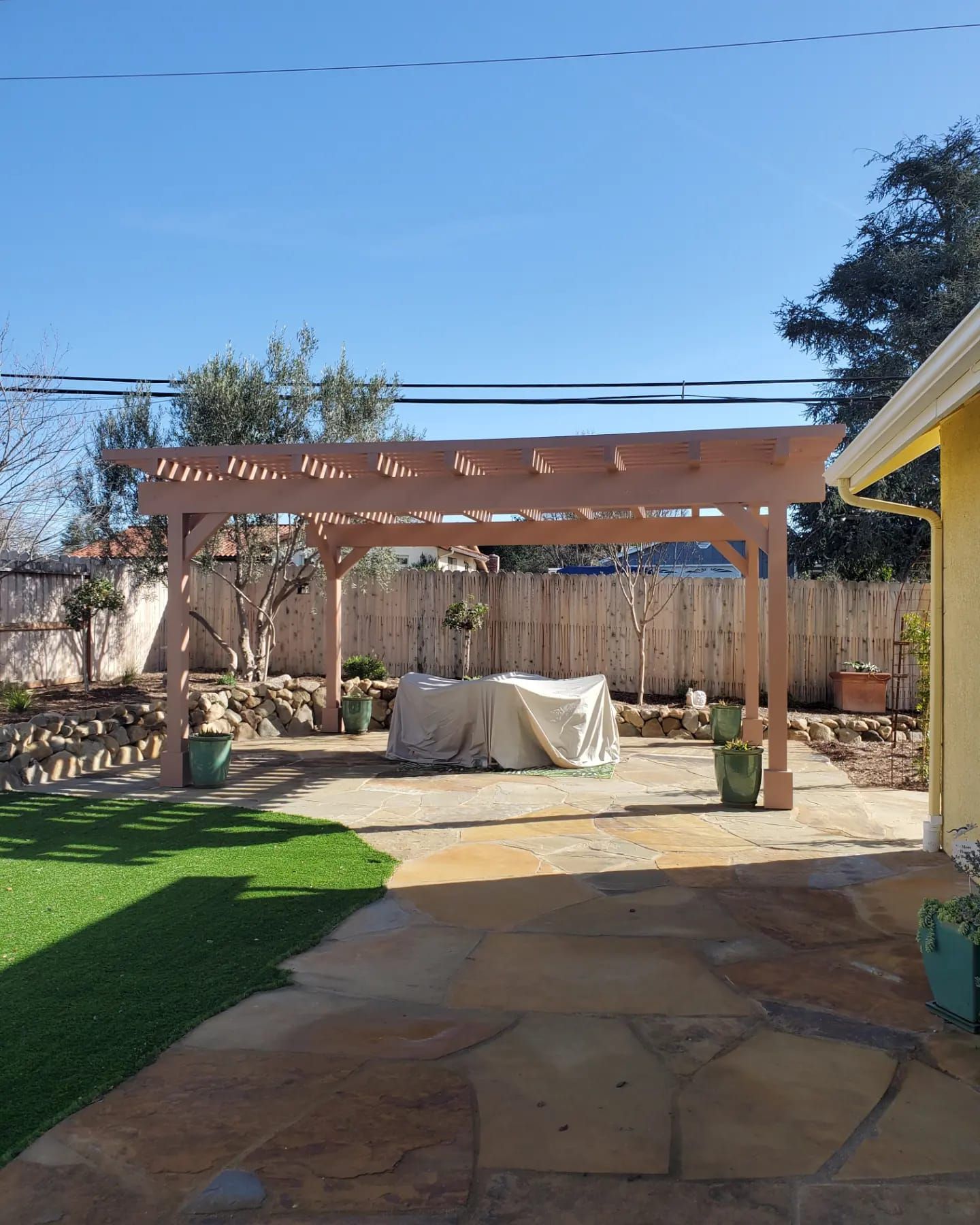 A wooden pergola with a blue sky in the background