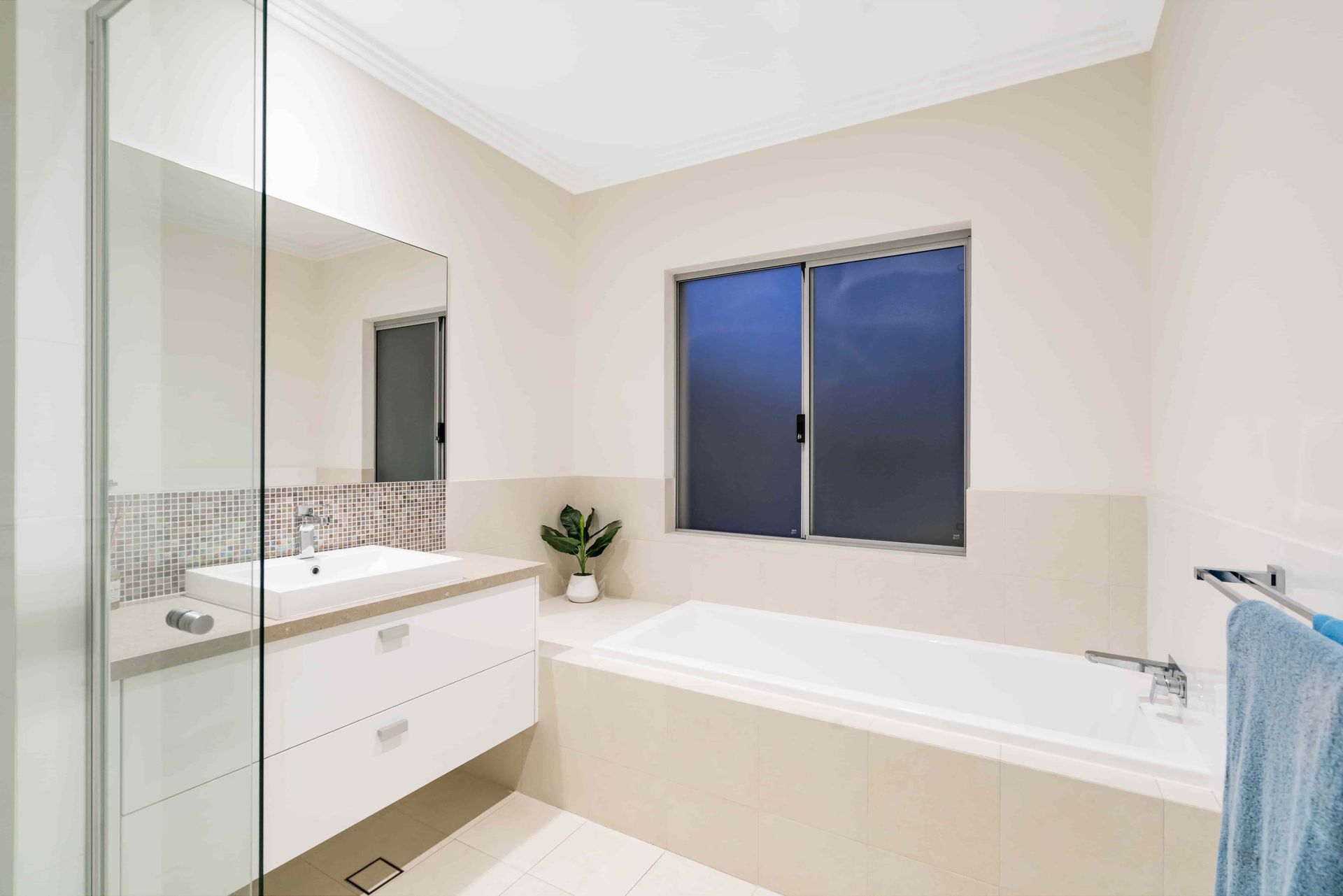 A bathroom with a tub , sink , mirror and window. — Andrew Logan Building In Wellington, NSW