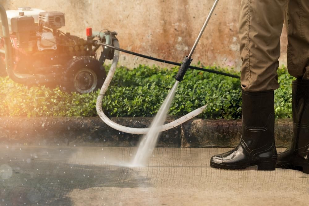 A Person Is Using A High Pressure Washer To Clean A Sidewalk — Torque Tech Supply & Repairs In Port Macquarie, NSW