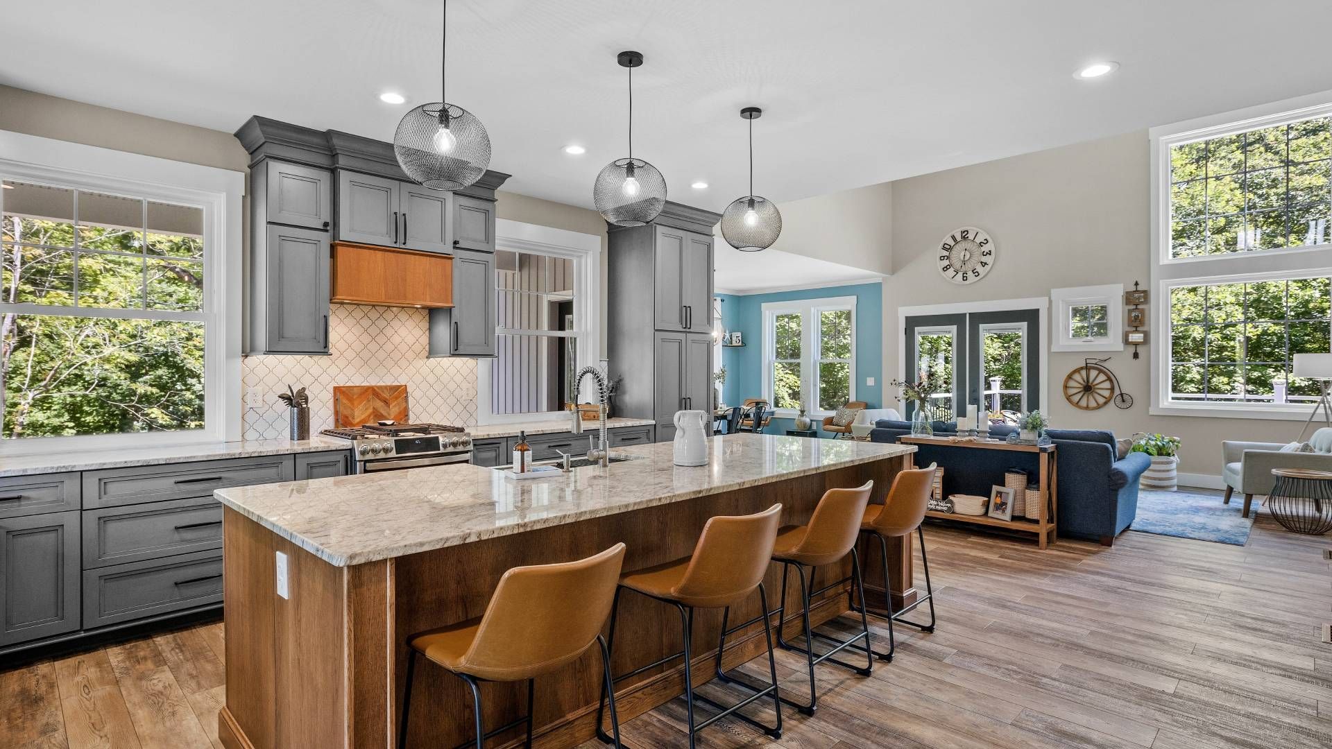 A modern kitchen and living room space with lots of windows at Schön Interiors near Braunfels, Texas