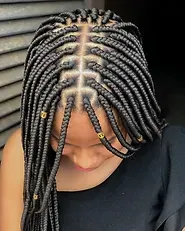 A woman with braids in her hair is wearing a black shirt
