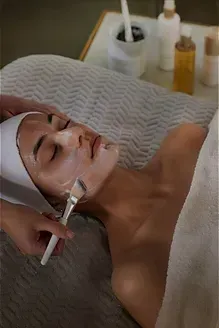 A woman is getting a facial treatment at a spa