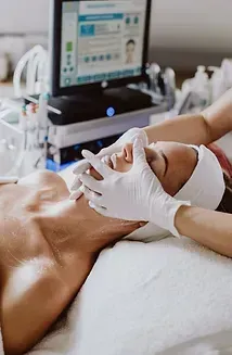 A woman is laying on a bed getting a facial treatment