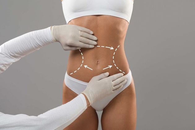 A woman 's stomach is being examined by a doctor