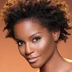 A close up of a woman 's face with curly hair