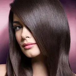 A woman with long brown hair and pink lips is looking at the camera