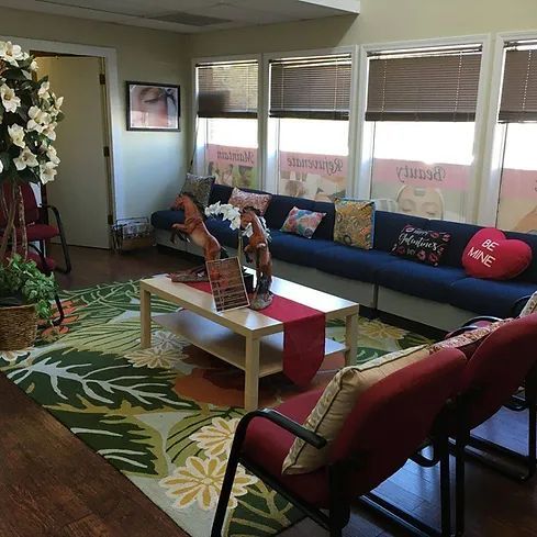 A living room with a couch , chairs , a coffee table and a rug.