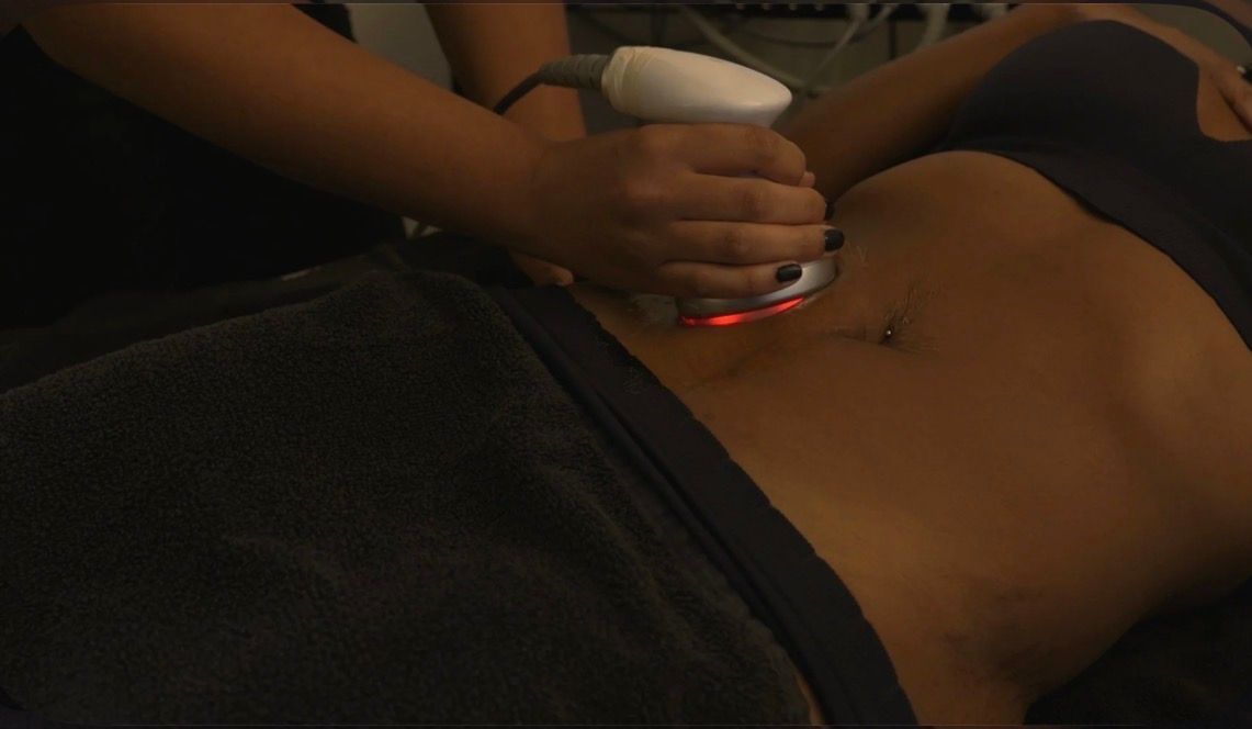 A woman is getting an ultrasonic cavitation treatment on her legs