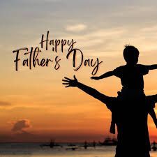 A silhouette of a man carrying a child on his shoulders.