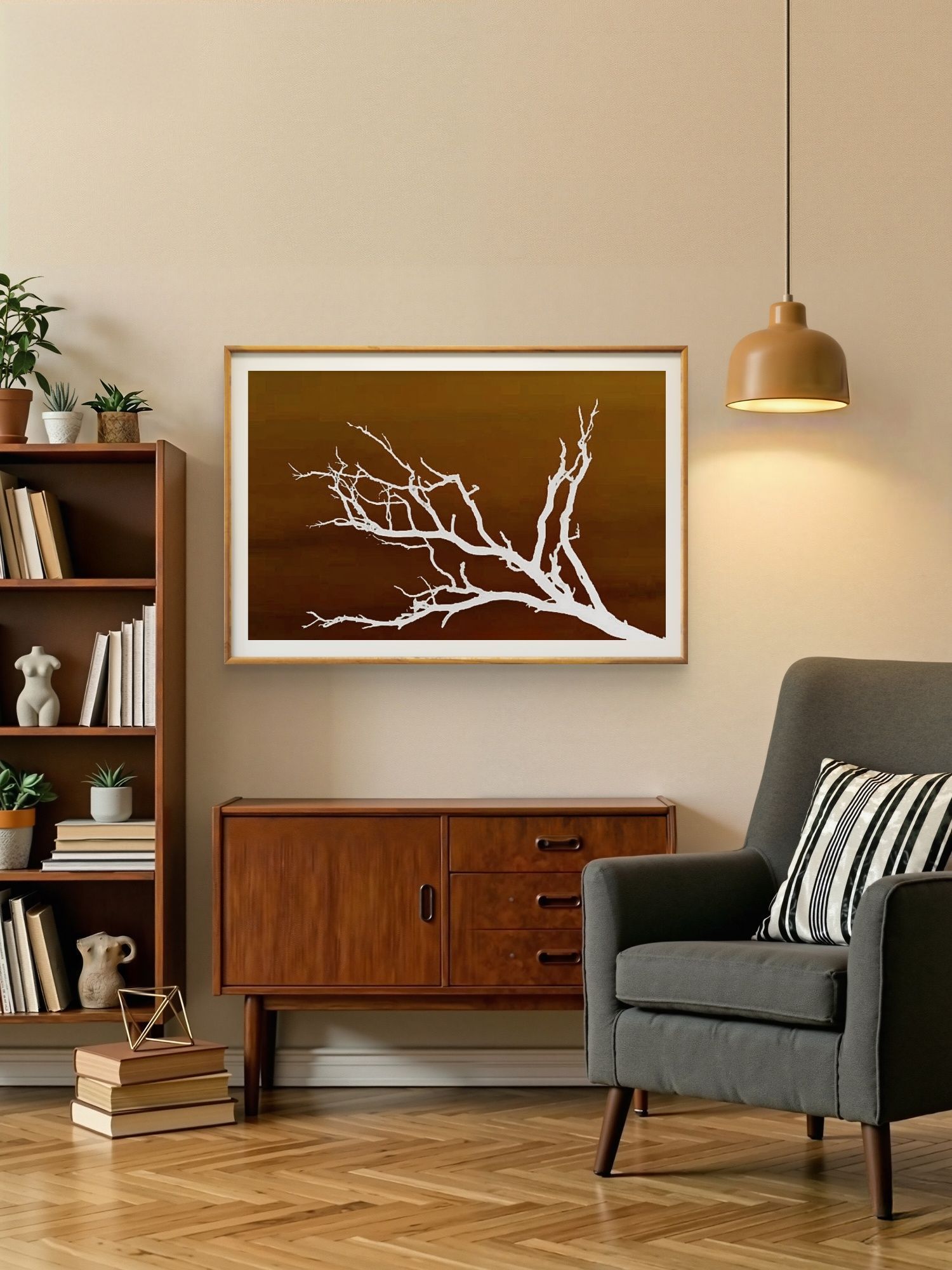 Modern living room with gray armchair, wooden cabinet, bookshelf, and framed white branch art on a beige wall