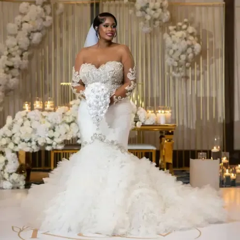 The bride is wearing a white wedding dress and holding a bouquet of flowers.