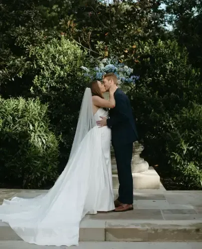 A bride and groom kissing on a set of stairs