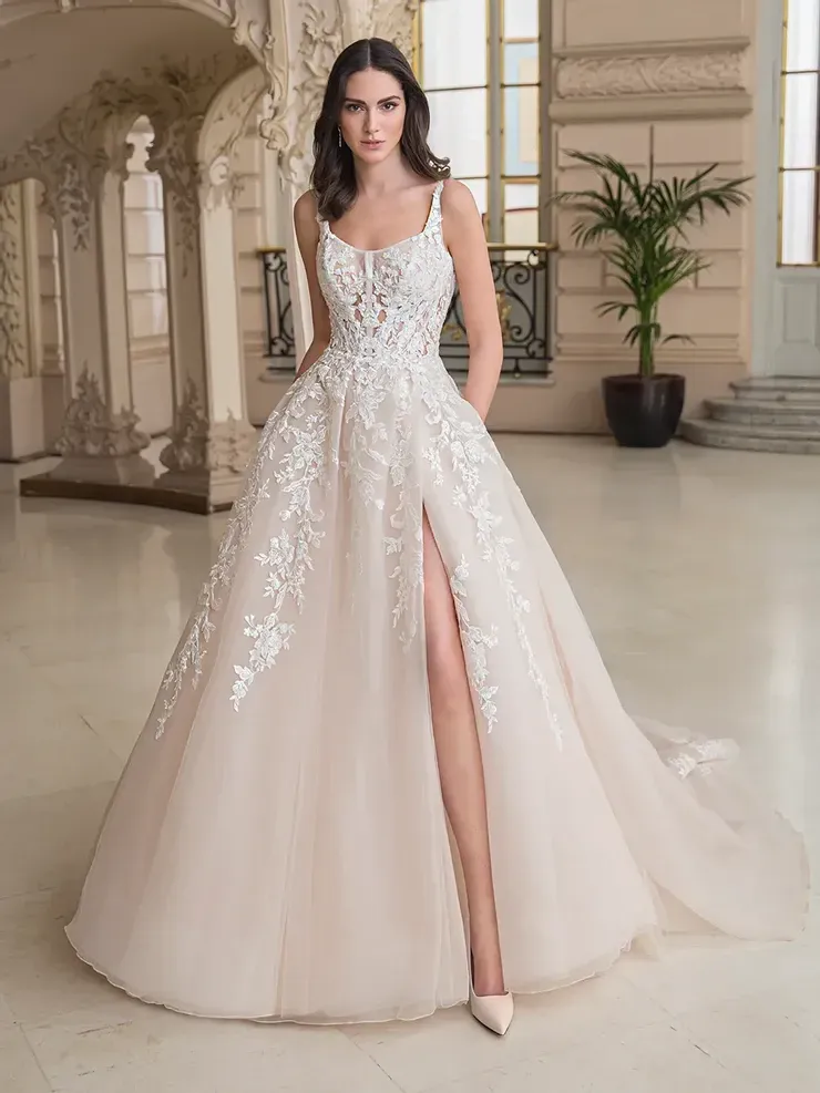 A woman is wearing a white wedding dress with a high slit.